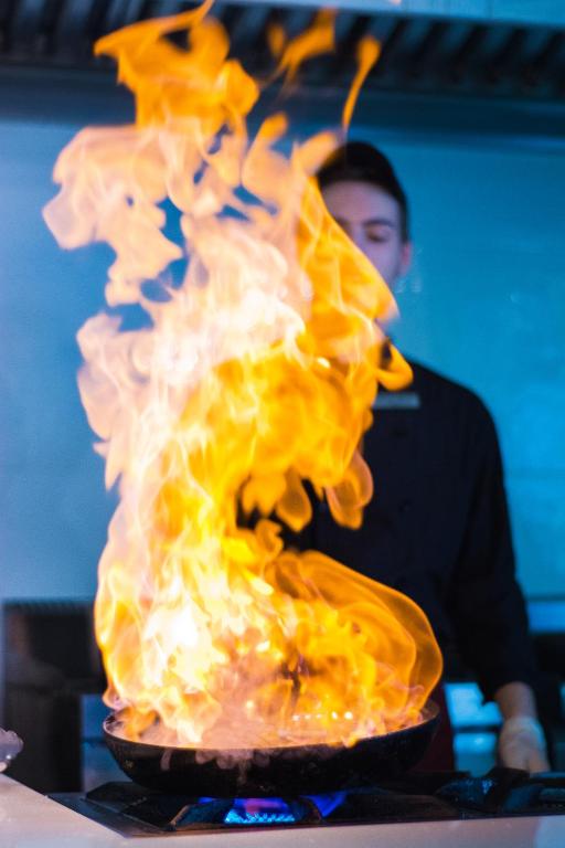 a pot of fire in front of a man at Hydrele Beach Hotel & Village in Potokáki