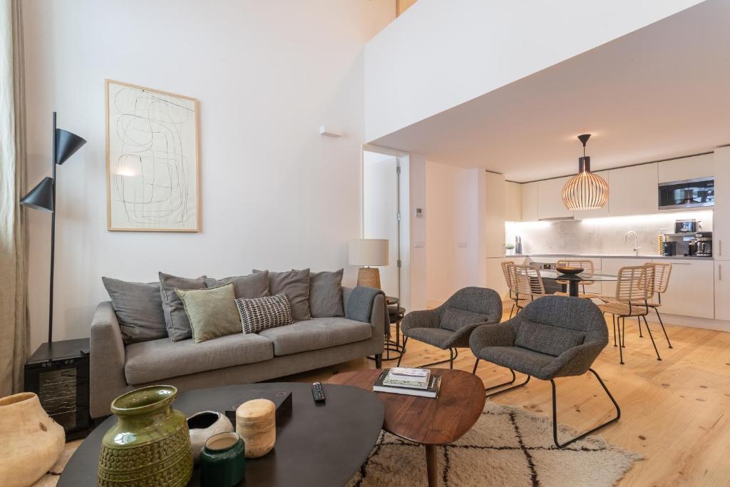 salon z kanapą, krzesłami i stołem w obiekcie FLH Cais Sodré Design Duplex - Ribeira 11 w Lizbonie