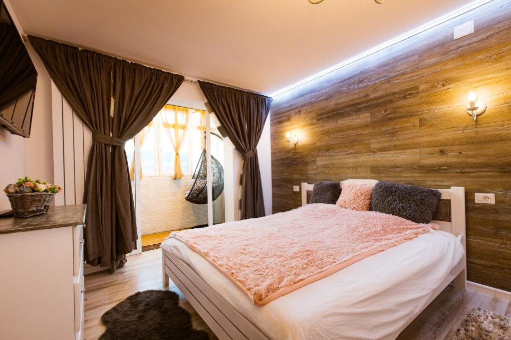 - une chambre avec un lit et un mur en bois dans l'établissement Apartament Maria, à Alba Iulia