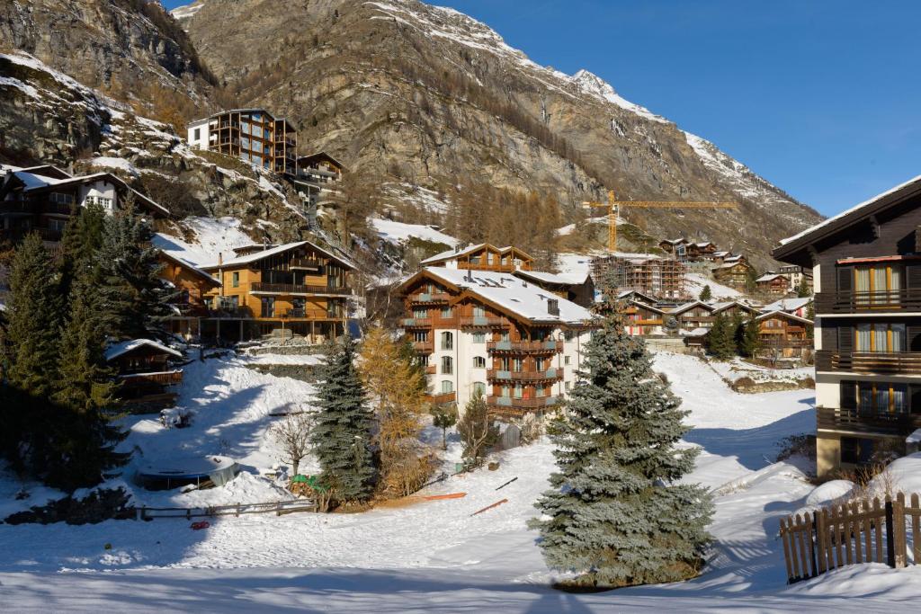 uma aldeia na neve com uma montanha em Haus Haro em Zermatt