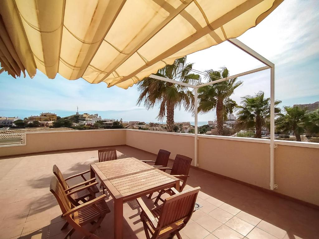 蓋博德帕洛斯的住宿－Apartamento con 129m2 de Terraza con vistas，阳台的天井配有桌椅