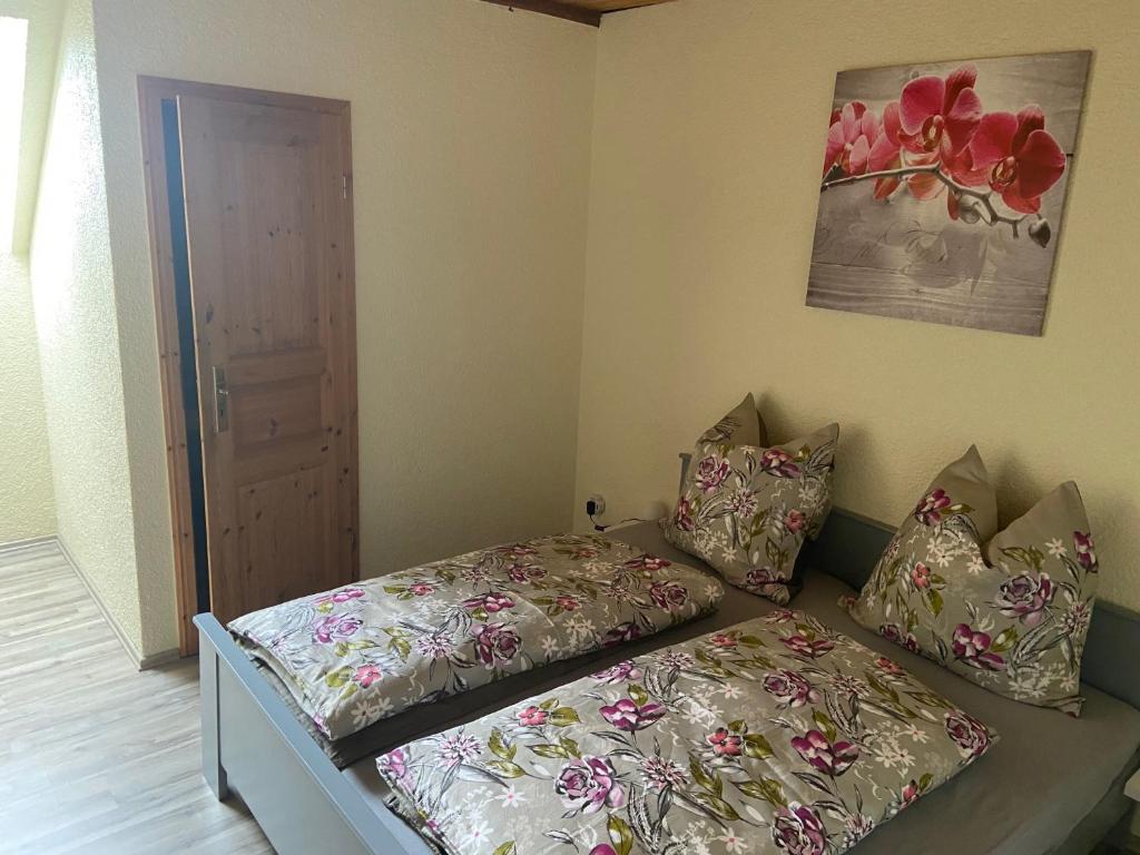 een kleine slaapkamer met een bed en kussens erop bij Zimmervermietung Graupner in Rossau
