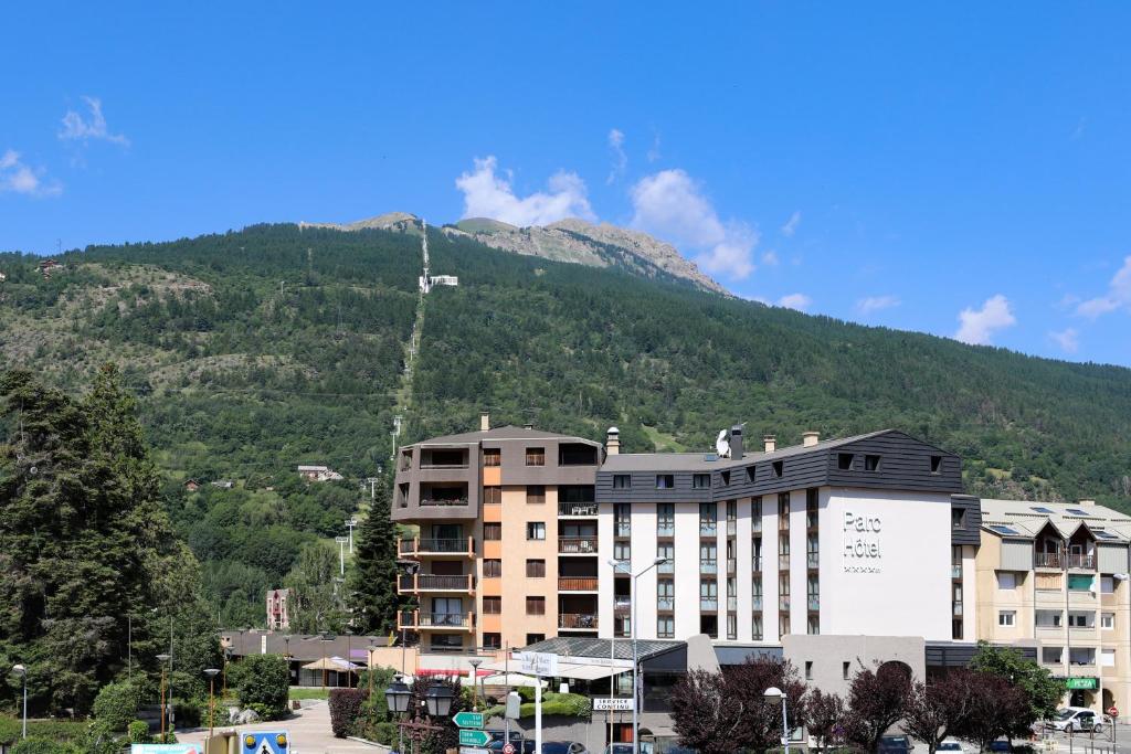 een groot gebouw voor een berg bij SOWELL HOTELS Le Parc & Spa in Briançon