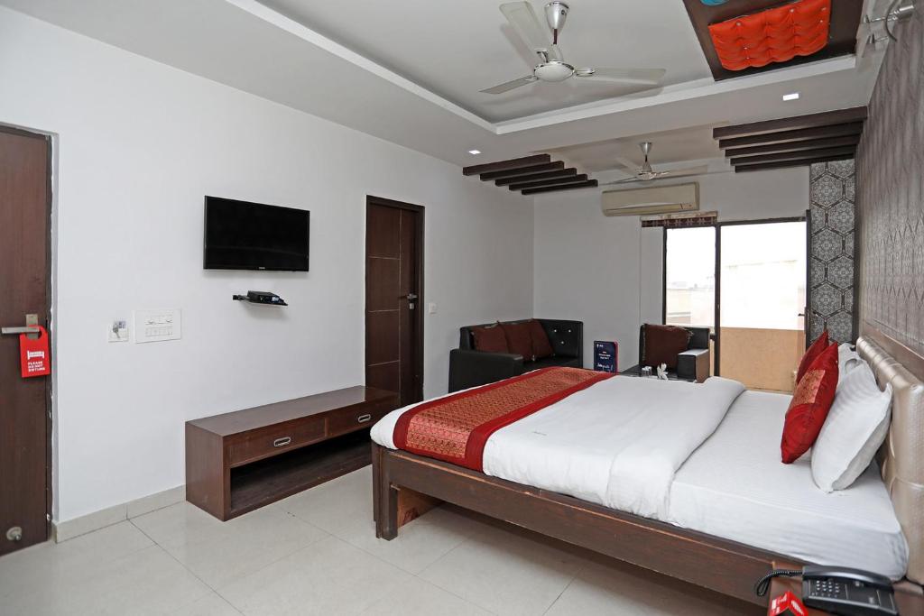 1 dormitorio con 1 cama y TV en la pared en Hotel Flora Inn, en Gurgaon