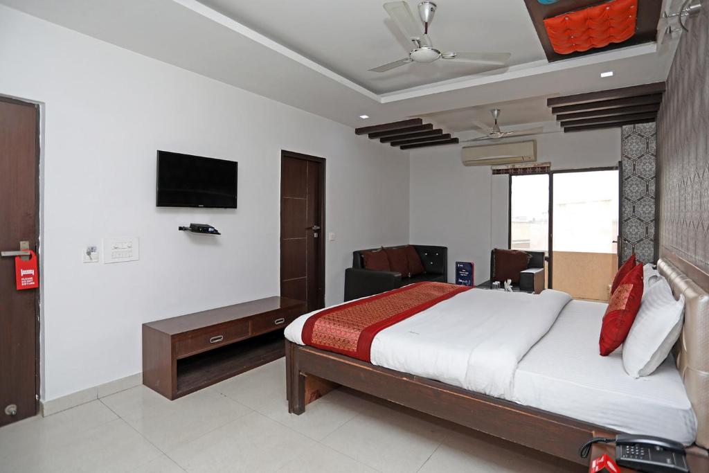 a bedroom with a bed and a tv on the wall at Hotel Flora Inn in Gurgaon