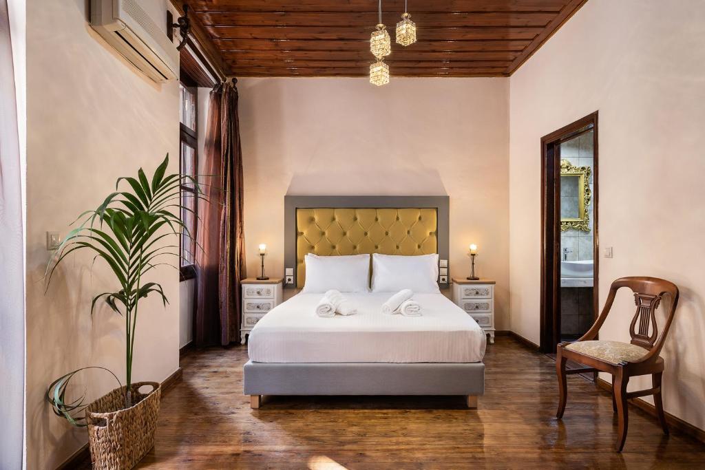 una camera con un letto bianco e una sedia di Old Town Suites a Chania