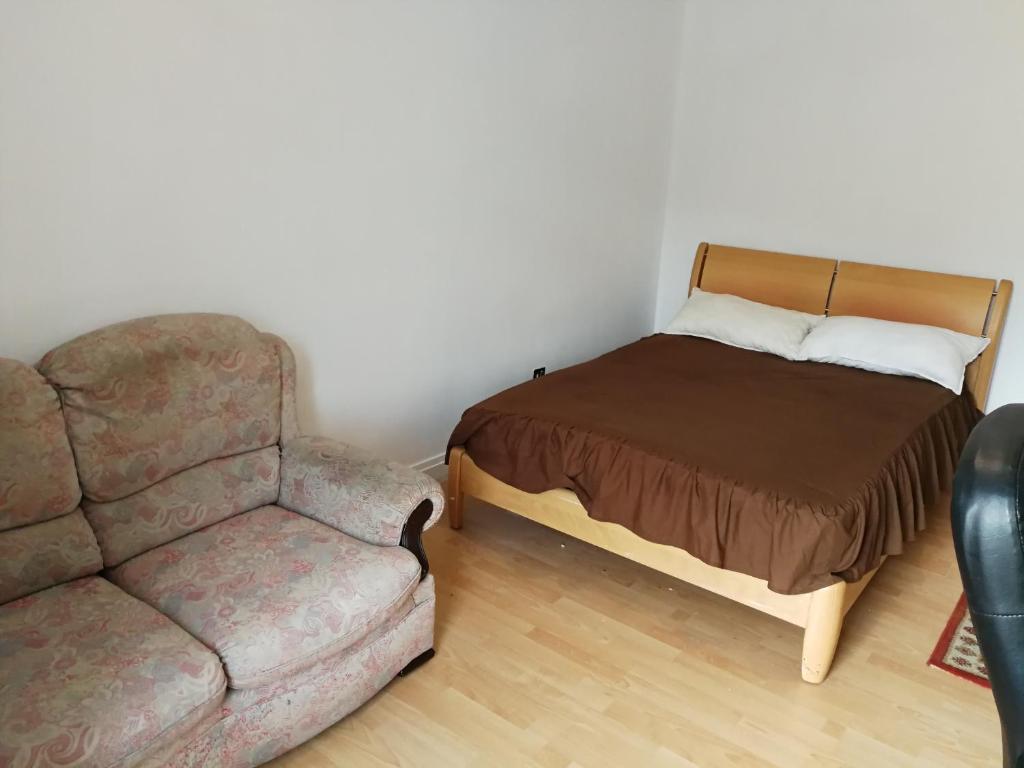 a bedroom with a couch and a bed and a chair at Budget Double Bedroom Near Glasgow City Centre and West End in Glasgow