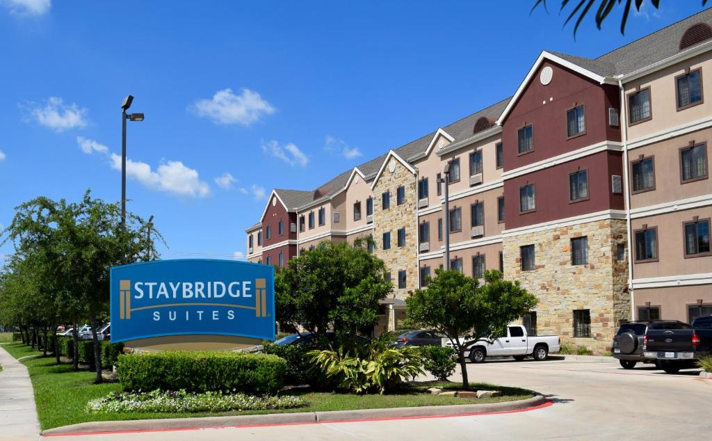 スタッフォードにあるStaybridge Suites Houston Stafford - Sugar Land, an IHG Hotelの大学院のスイートがある建物の前の看板