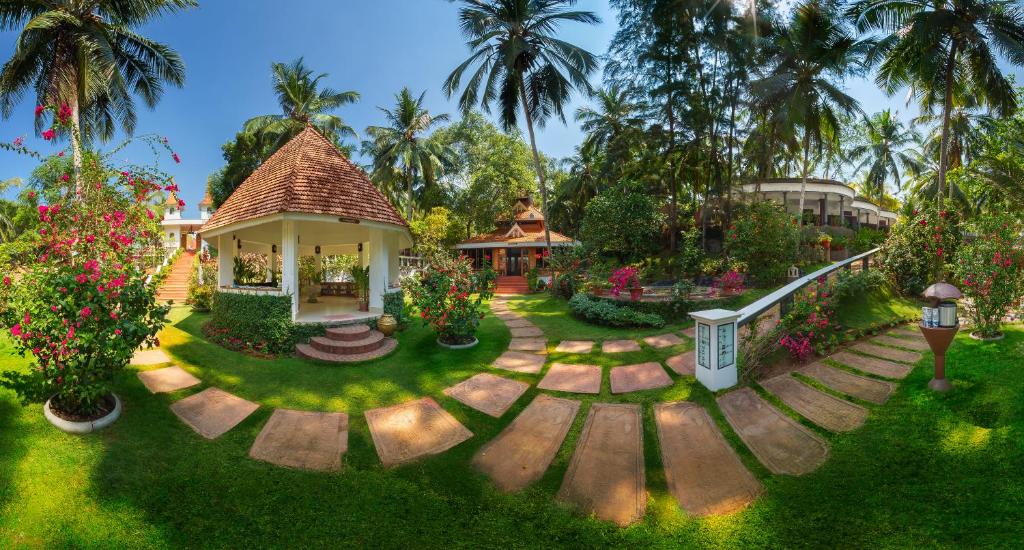 uma casa com jardim com flores e árvores em Bethsaida Hermitage em Kovalam