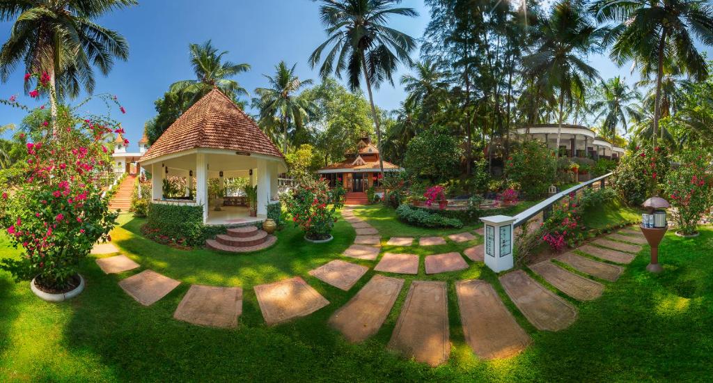 a house with a garden with flowers and trees at Bethsaida Hermitage in Kovalam