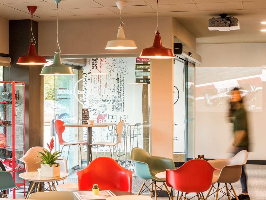 a restaurant with colorful chairs and a table at Ibis Montmelo Granollers in Granollers