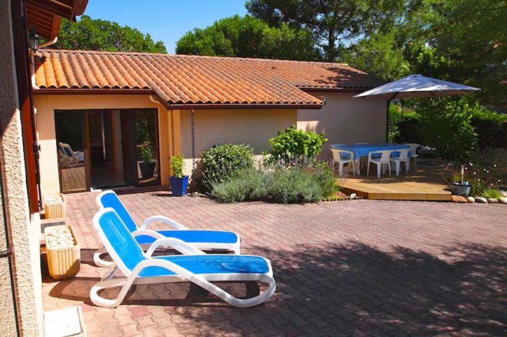 a pair of chairs and an umbrella in a yard at Holiday house close to the ocean in Lacanau-Ocean in Lacanau