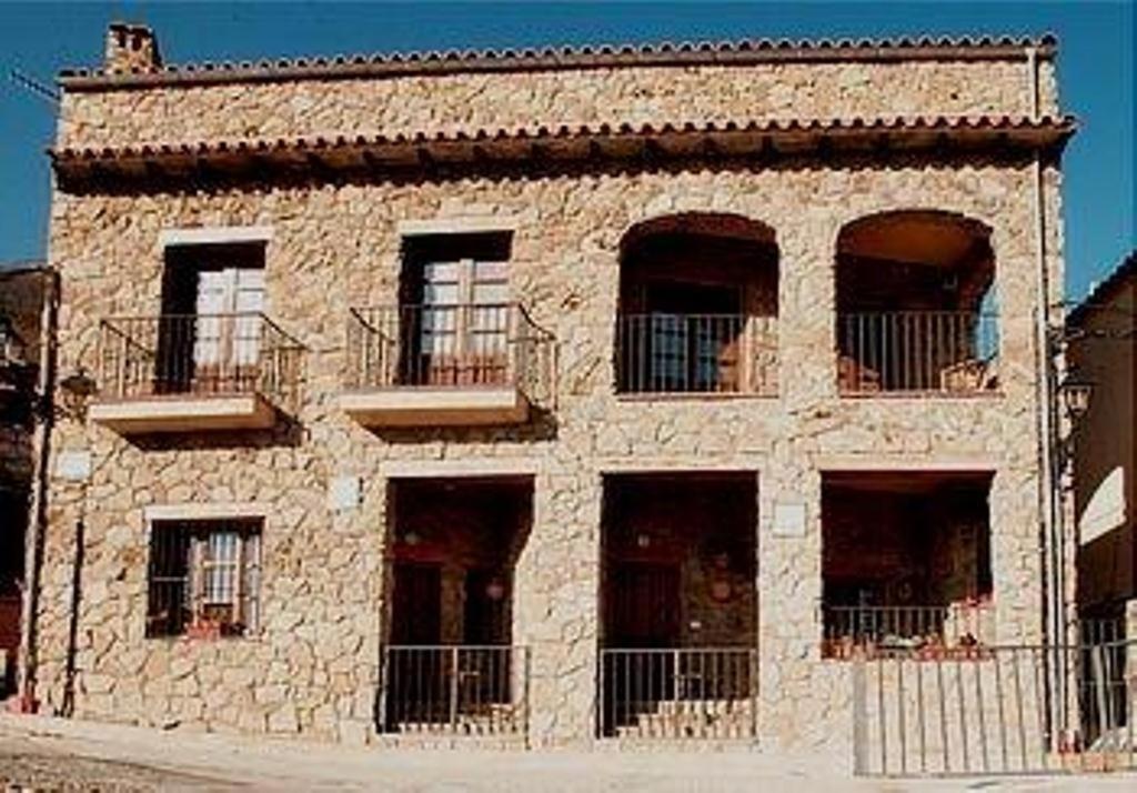 a large stone building with windows and balconies at Casa Rural Las Gamellas in Rebollar