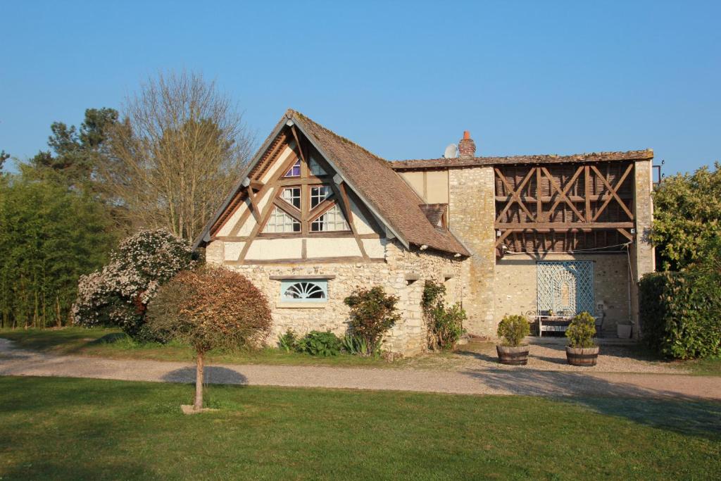 una grande casa in pietra con tetto a gambero di L'Etable du Domaine des Buissonnets a Écardenville-sur-Eure