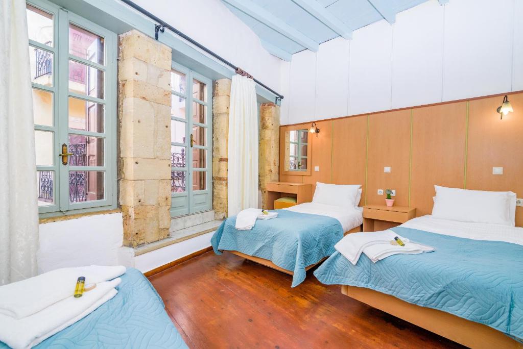 a room with two beds and two windows at Alegria Pension in Chania Town