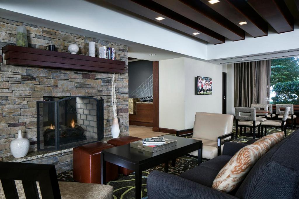 Staybridge Suites Atlanta - Midtown, an IHG Hotel في أتلانتا: غرفة معيشة مع موقد وأريكة