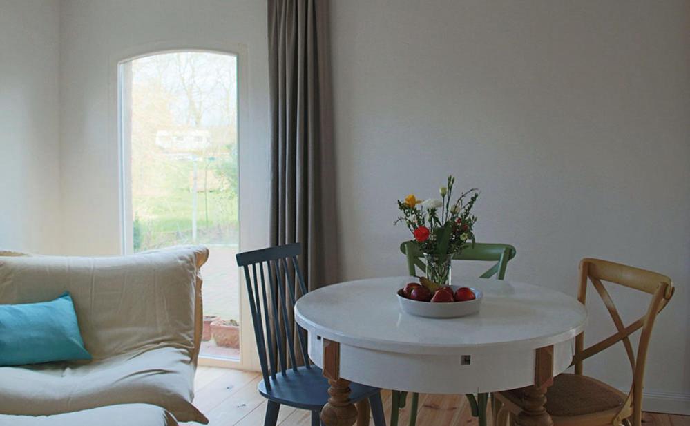 ein Wohnzimmer mit einem Tisch und einer Blumenvase in der Unterkunft GartenGlück in Nordleda