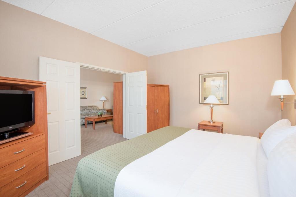 ein Hotelzimmer mit einem Bett und einem Flachbildfernseher in der Unterkunft Holiday Inn & Suites Goodyear - West Phoenix Area by IHG in Goodyear