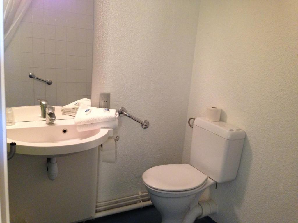 a bathroom with a toilet and a sink at ibis budget Chartres in Chartres
