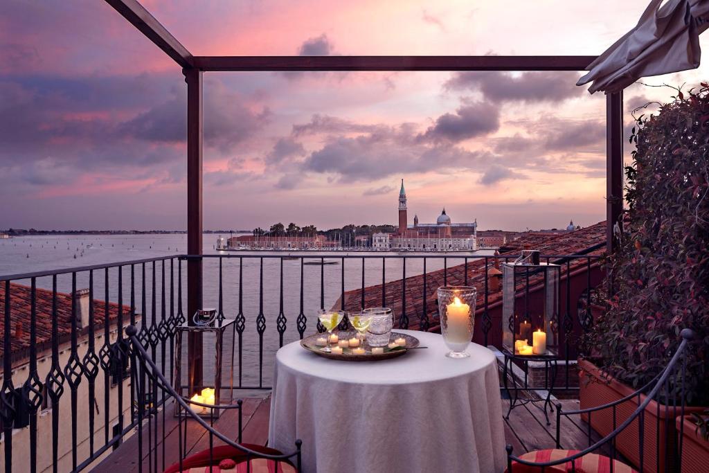a table on a balcony with a view of the water at Hotel Metropole Venezia in Venice