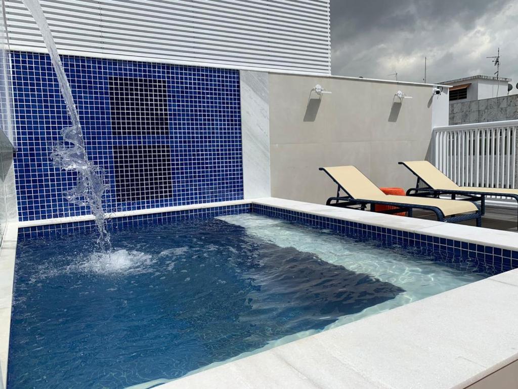 a swimming pool with a water fountain on a rooftop at Petit Rio Hotel in Rio de Janeiro
