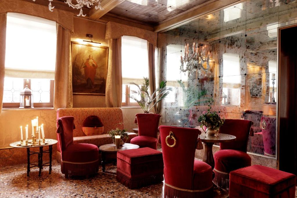 a restaurant with red chairs and a couch and tables at Hotel Metropole Venezia in Venice