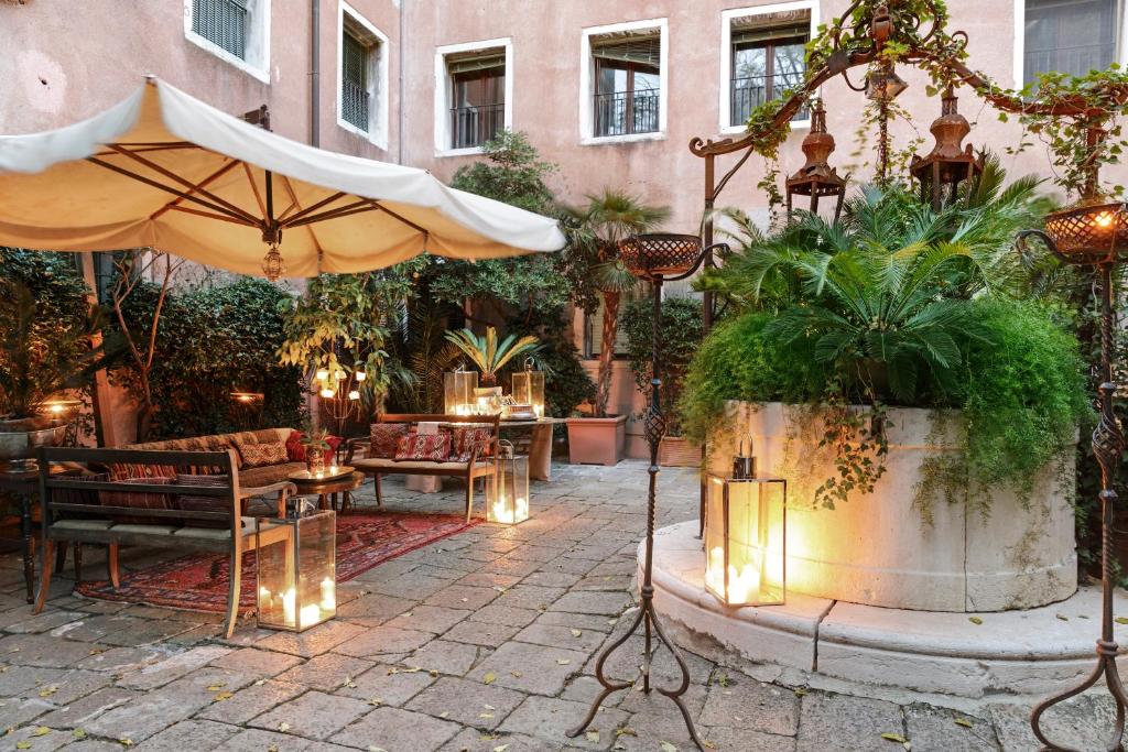an outdoor patio with an umbrella and tables and chairs at Hotel Metropole Venezia in Venice