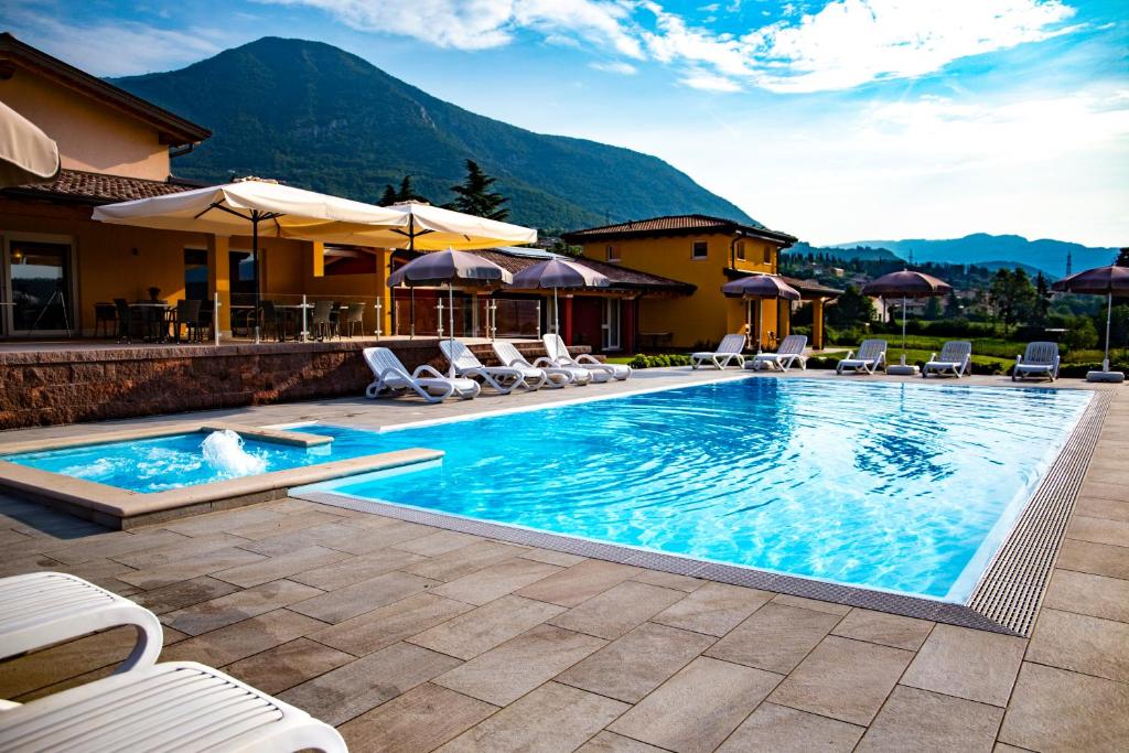 a large swimming pool with chairs and a house at B&B Ca' Marognole in Caprino Veronese