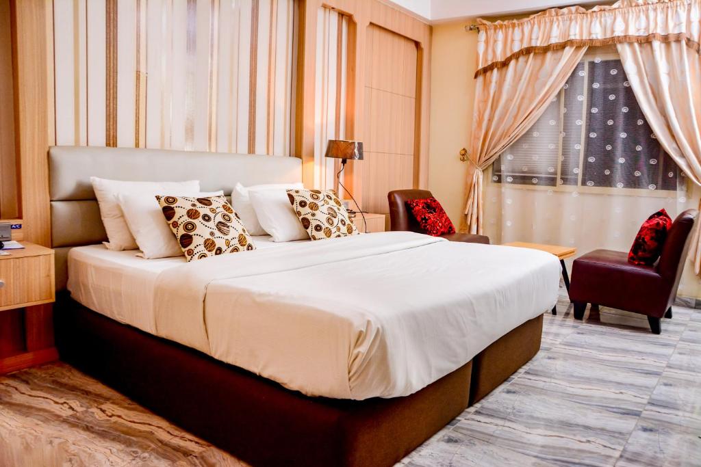 a hotel room with a bed and a window at GolfView Suites & Conference Center in Ikeja
