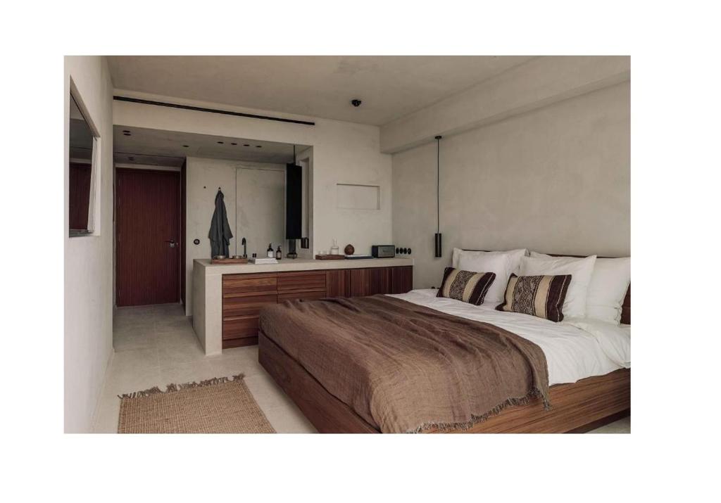a bedroom with a large bed and a bathroom at OKU Ibiza in San Antonio