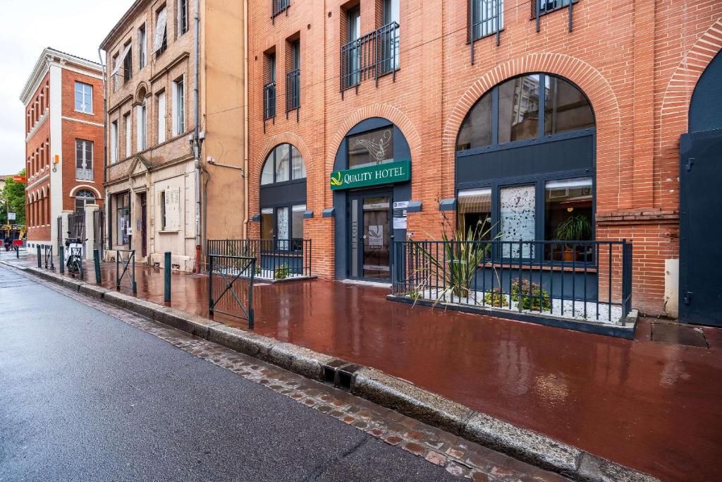 an empty street in front of a brick building at Quality Hotel Toulouse Centre in Toulouse