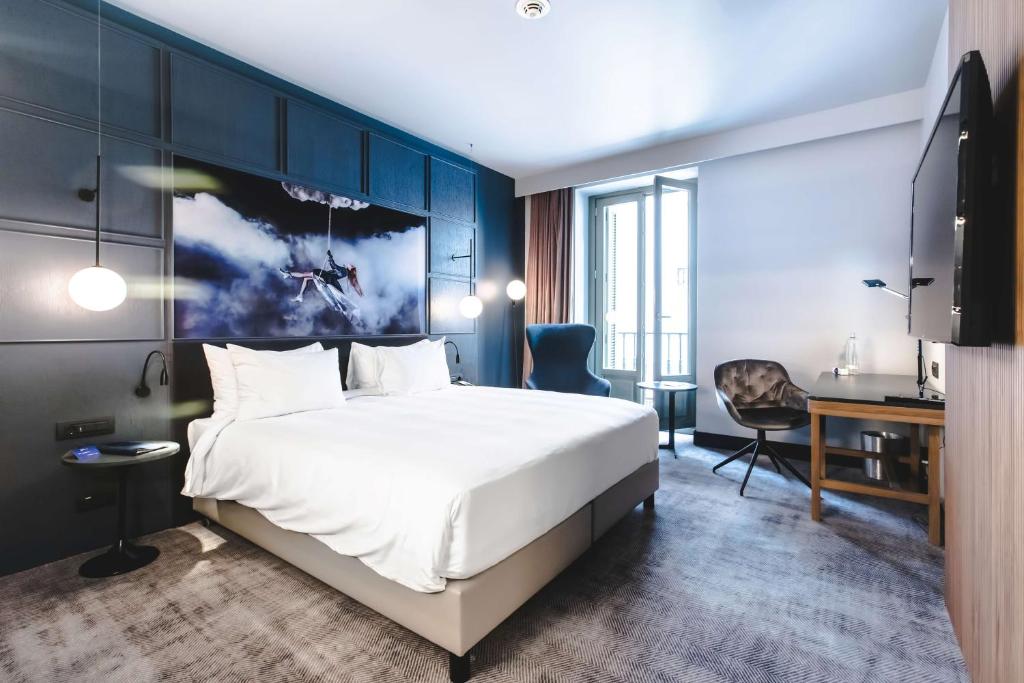 a hotel room with a large bed and a desk at Radisson Blu Hotel, Madrid Prado in Madrid