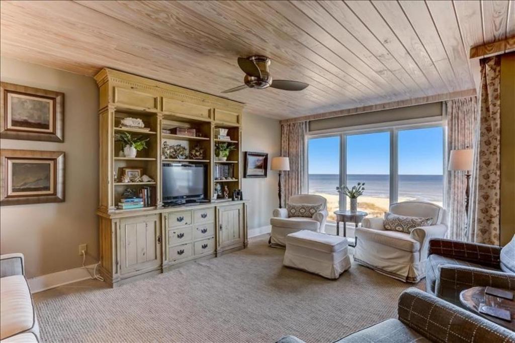 Una sala de estar con televisión y una gran ventana. en Oceans Of Amelia, en Fernandina Beach