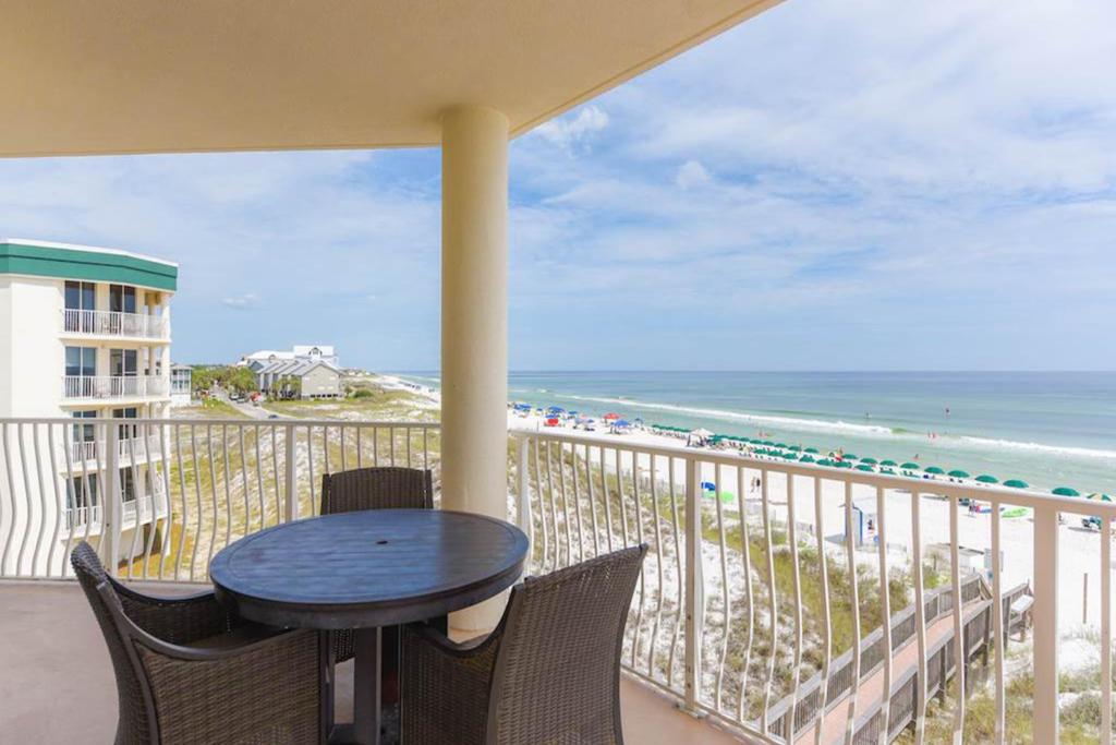 a balcony with a table and chairs and the beach at Dunes of Seagrove Condos in Santa Rosa Beach