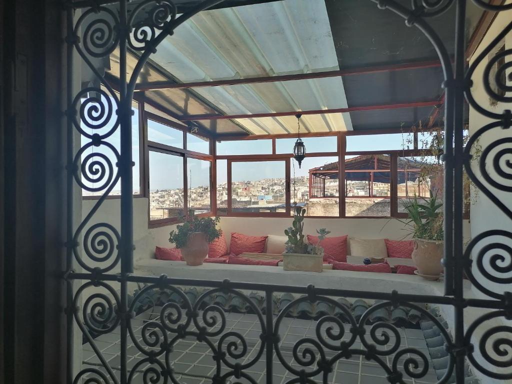 a balcony with a couch in a room with windows at Dar atlas in Fès