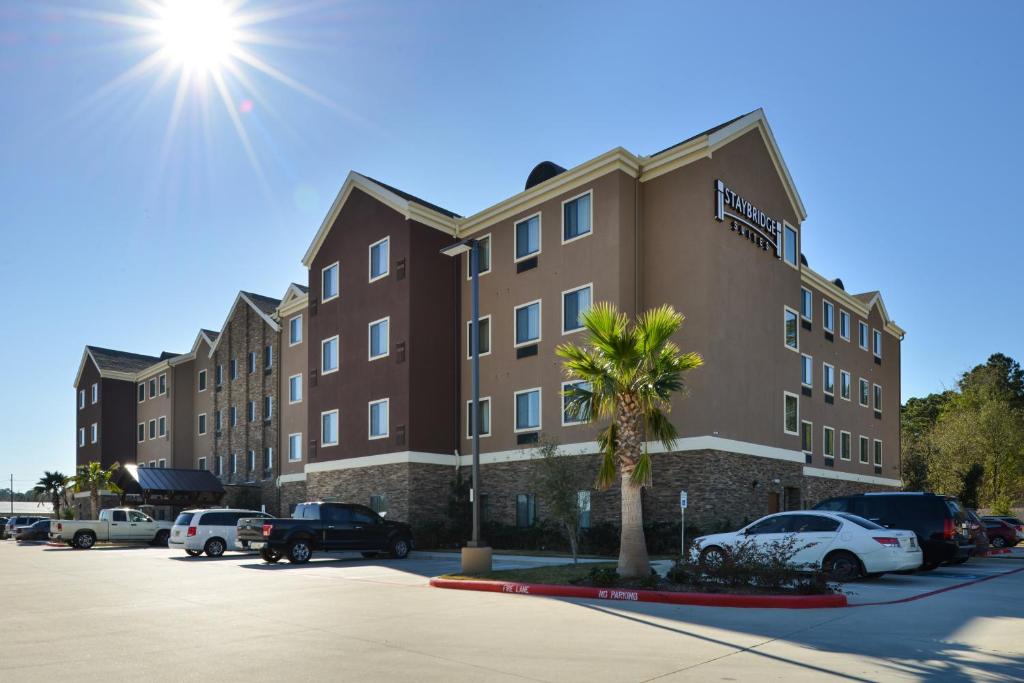 een gebouw met auto's geparkeerd op een parkeerplaats bij Staybridge Suites Tomball, an IHG Hotel in Tomball