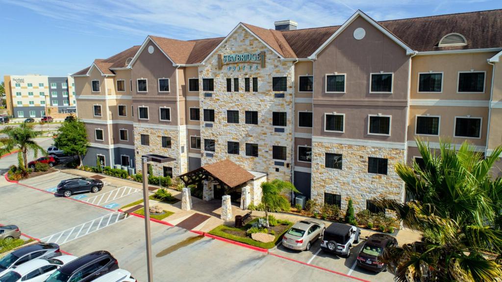 an aerial view of a hotel with cars parked in a parking lot at Staybridge Suites Houston-NASA Clear Lake, an IHG Hotel in Webster