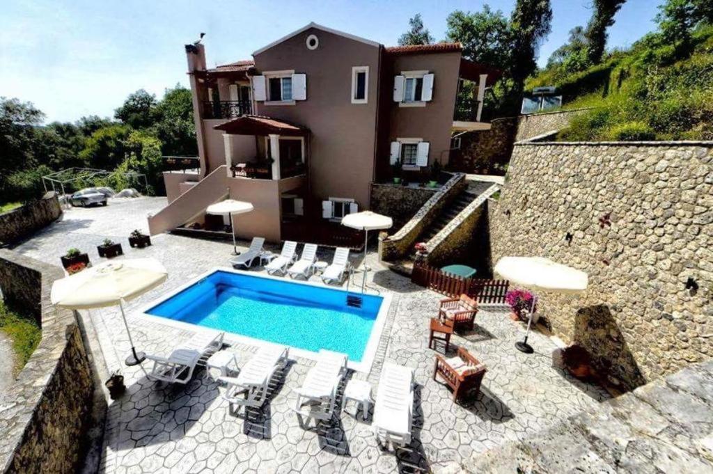 a villa with a swimming pool in front of a house at Villa Natalia in Kouramádes