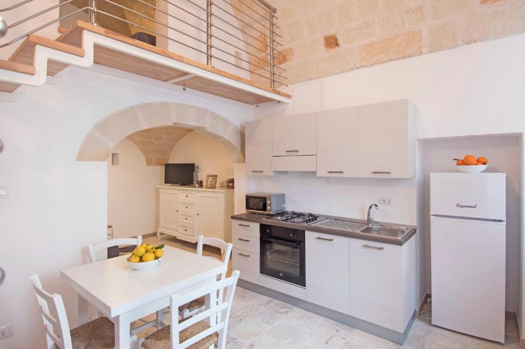 eine Küche mit einem Tisch und einem weißen Kühlschrank in der Unterkunft Apulianstay-Via Cavour 22 in Monopoli
