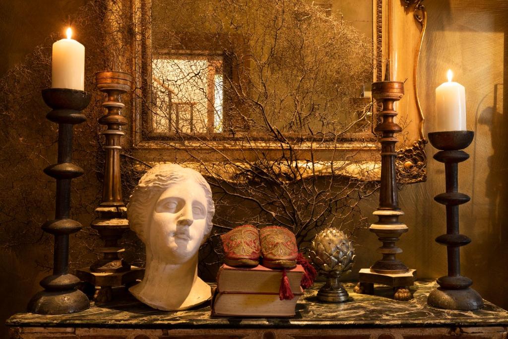 a statue of a head and candles on a table at Hotel Metropole Venezia in Venice