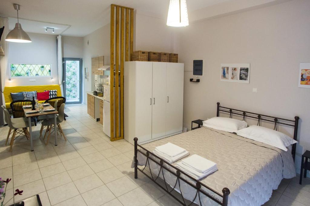 a bedroom with a bed and a kitchen and a table at Luxurious Studio, near Athens Airport in Markopoulo