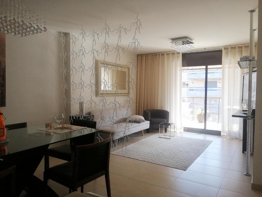 Una sala de estar con una mesa de comedor y una sala de estar con un sofá. en Apartamento Salou lux por precio económico., en Salou