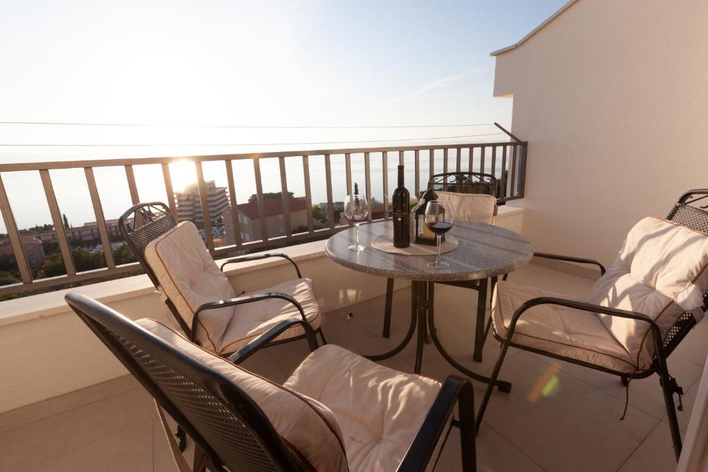 a balcony with a table and chairs on a balcony at Apartments Galic in Podgora