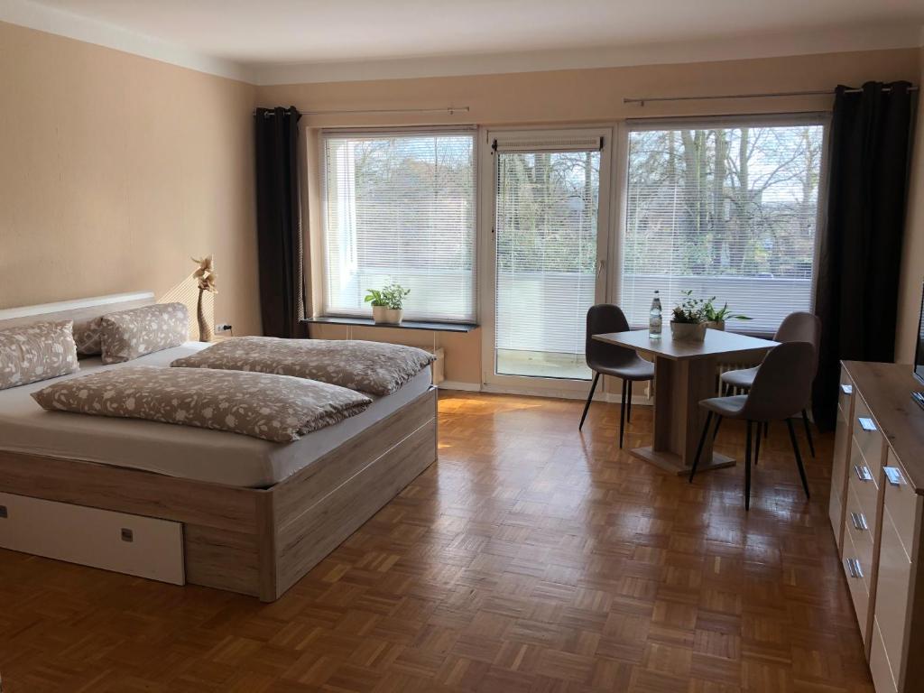 Schlafzimmer mit einem Bett, einem Tisch und Stühlen in der Unterkunft Super Lage, neu renovierte, gemütliche Unterkunft in Lübeck