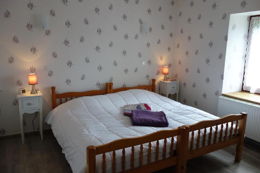 Un dormitorio con una cama con una bolsa morada. en Le Champ, en Le Clerjus
