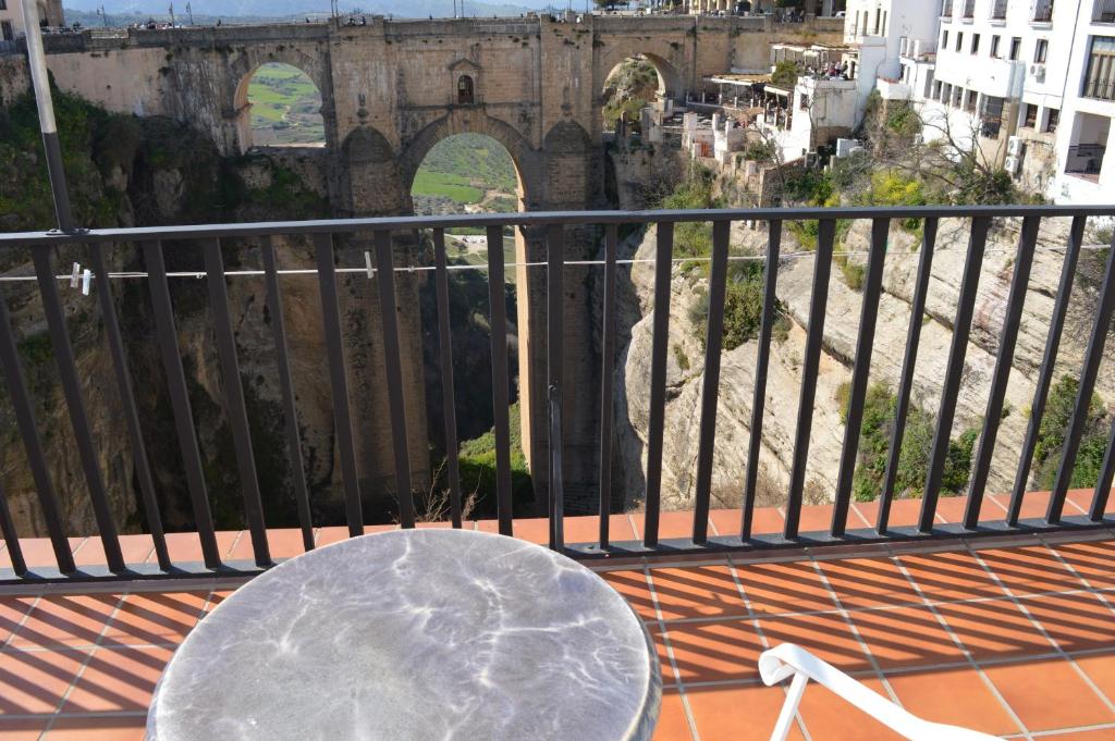 a table on a balcony with a view of a bridge at Casa Duende del Tajo in Ronda