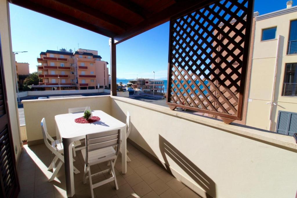 d'un balcon avec une table, des chaises et une fenêtre. dans l'établissement Rif. B16 - MEDITERRANEO, à San Vincenzo