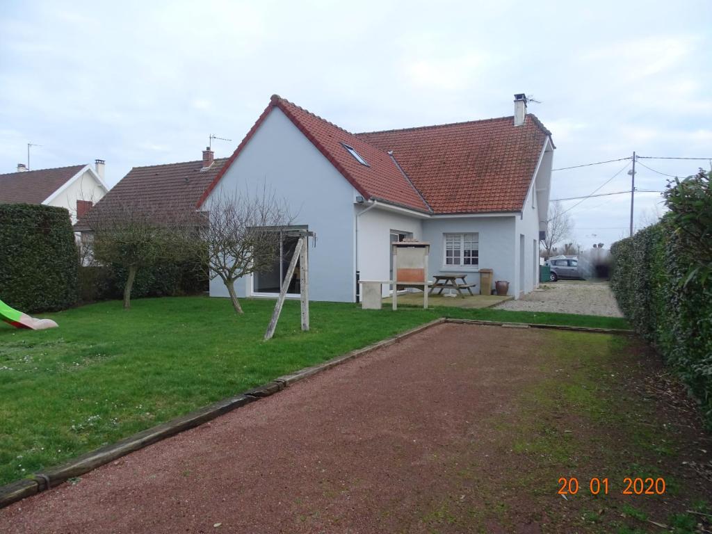 uma casa branca com um parque infantil no quintal em Les Mésanges em Fort-Mahon-Plage