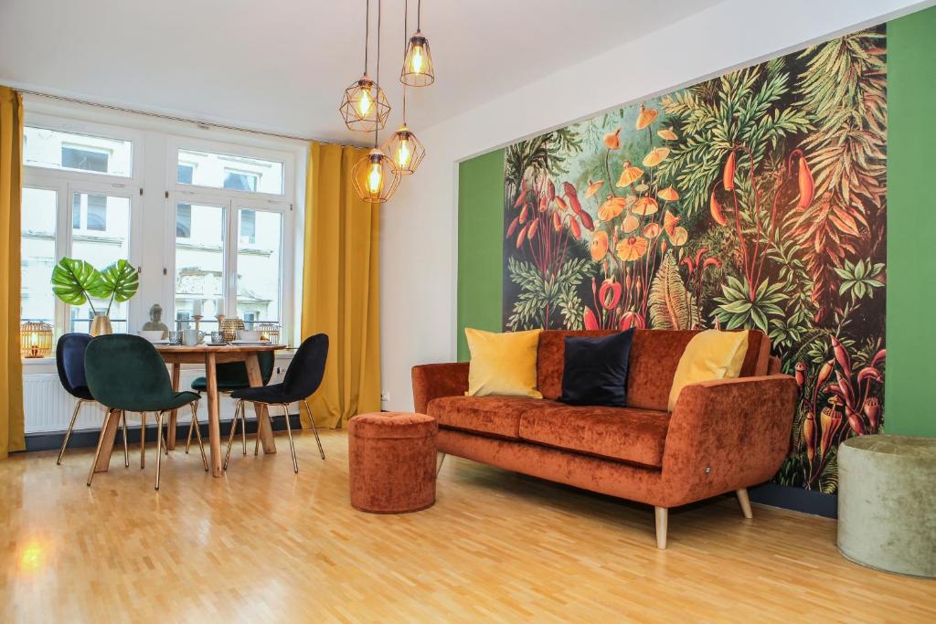 een woonkamer met een bank en een tafel met stoelen bij Sleepwell Apartment - Klostersuite in Leipzig