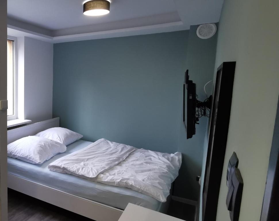 Un pat sau paturi într-o cameră la YO!Apartments Kotwiczników